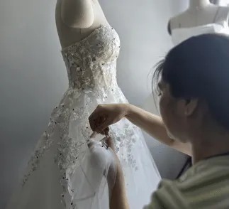 couturière qui réalise une robe de mariée